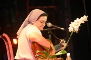 Hermana Glenda en escaleras con una guitarra